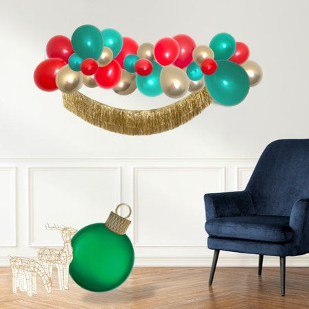 My Party Box Christmas Balloon Garland DIY with red, emerald Green and chrome gold color hanging on wall with golden Fringe garland 
