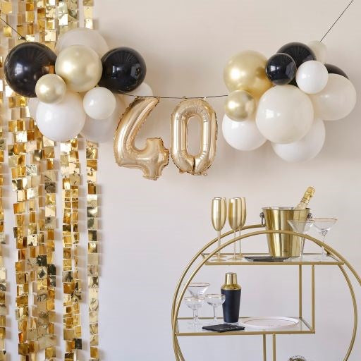 Ginger Ray 40th Birthday Milestone Balloon Bunting Decoration with mini numbers 40 and Black, White, Whitesand, Gold latex Balloons  set up with Gold wall decoration and gold cart