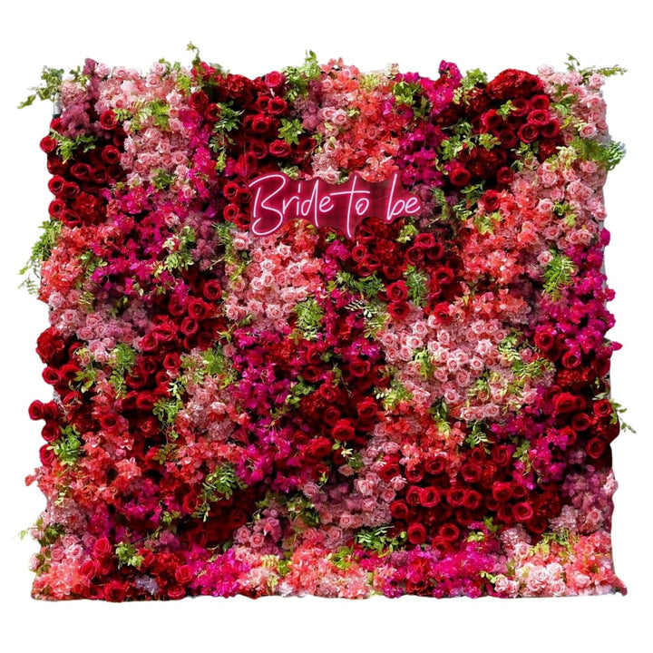 Floral rose wall with “Bride To Be” neon sign.