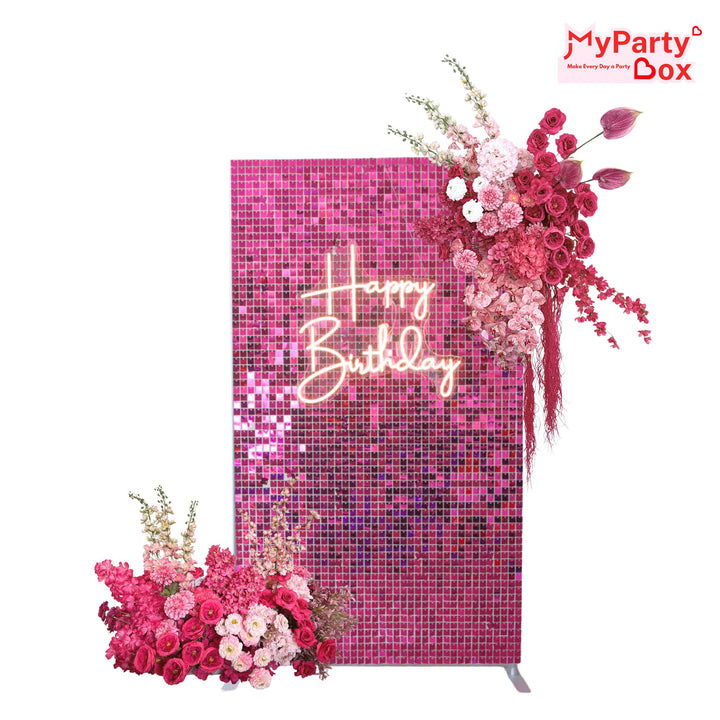 Shimmering pink sequin backdrop wall with a neon "Happy Birthday" sign and pink floral arrangements.