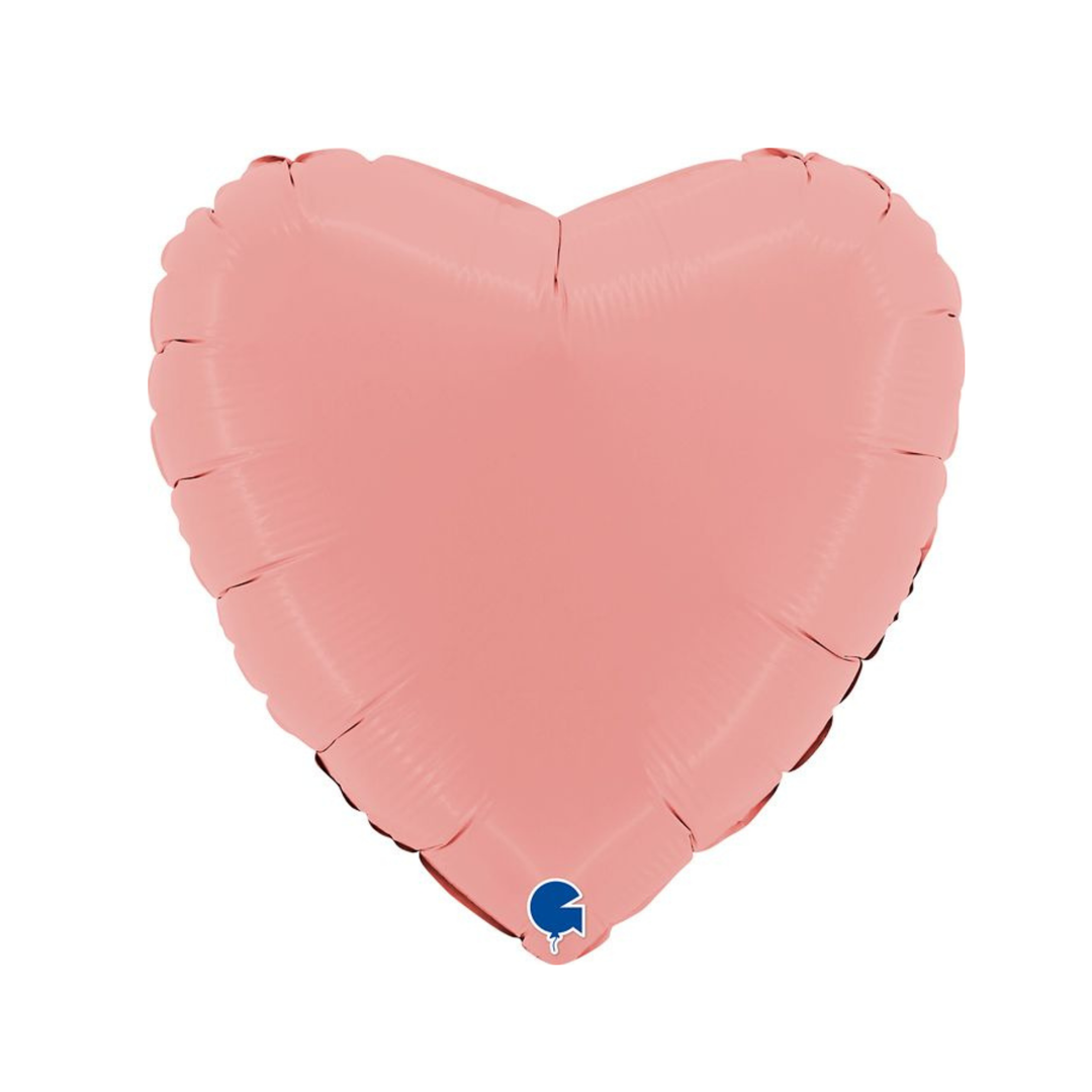 A pink heart-shaped foil balloon on a plain white background, with a small blue and white Valvoline logo near the bottom tip.