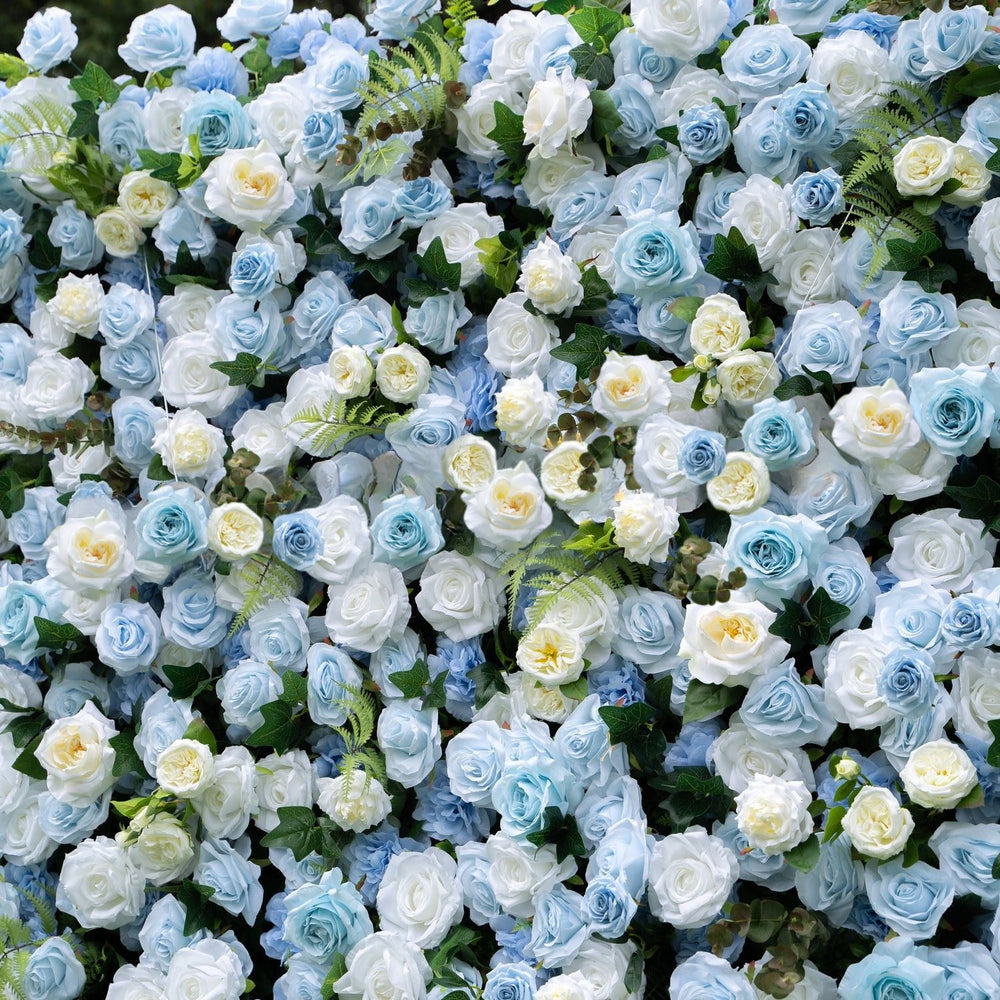Wall of artificial blue and white flowers with green leaves