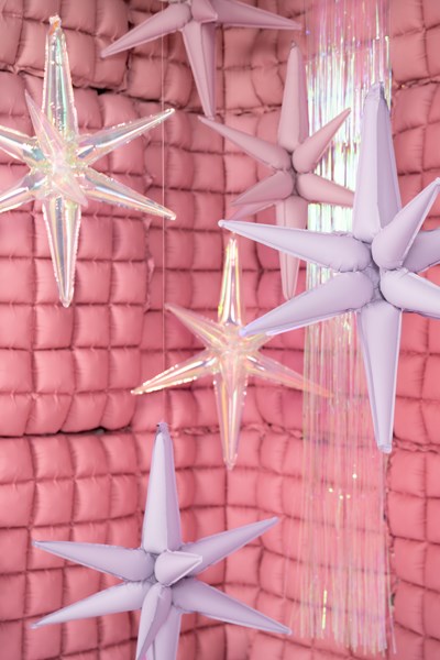 Star-shaped decorations hanging against a pink textured wall