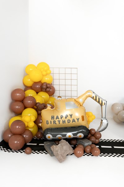 Birthday balloon setup with a construction vehicle and 'Happy Birthday' text on a white background