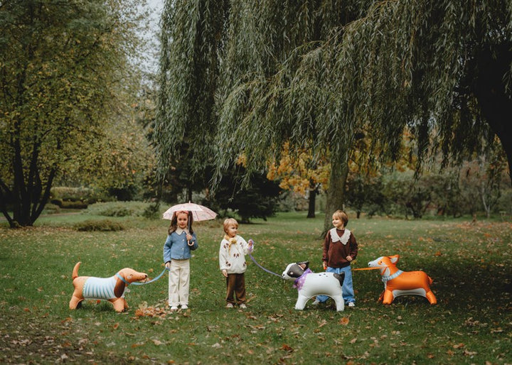 Children with inflatable dogs in a park setting