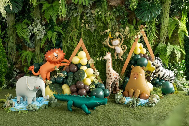 balloon animals including a lion, elephant, giraffe, and zebra in a jungle setting with plants and fruits.