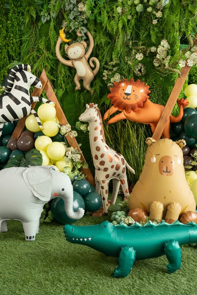 Collection of inflatable animal balloons on a green grass-like surface with a forest background.