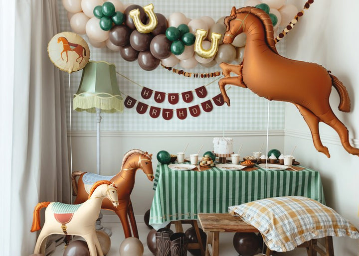 Children's birthday party setup with horse-themed balloons and decorations.