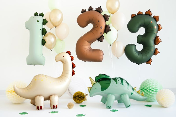 Dinosaur-themed balloons and figurines on a white background