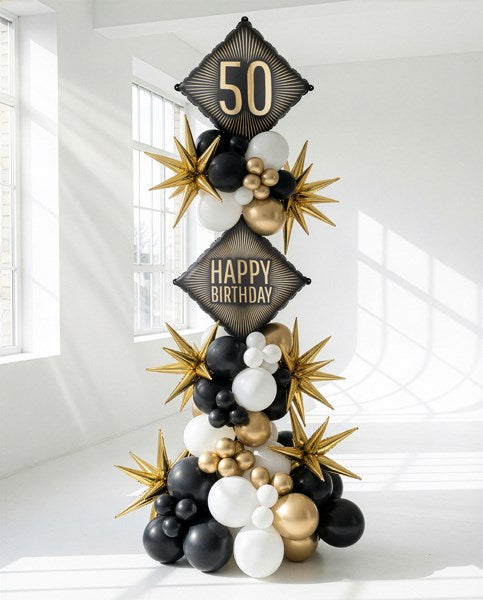 Decorative balloon arch with 'Happy Birthday' and '50' text in black, gold, and white on a white background.