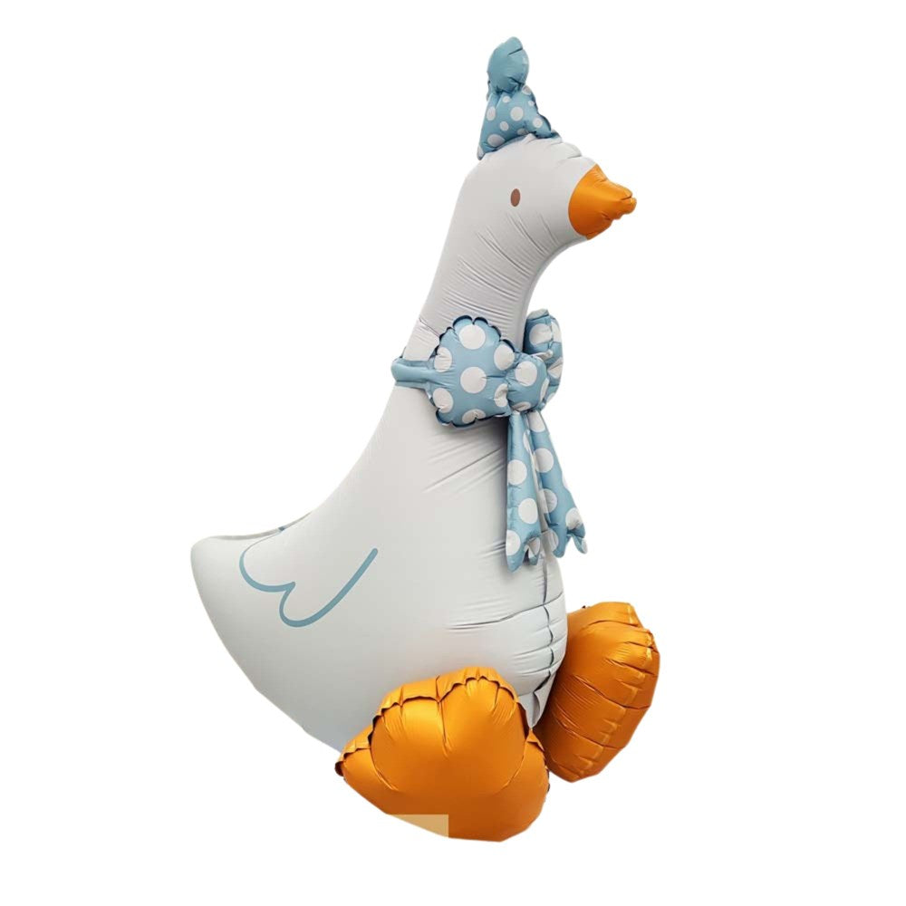 A large inflatable foil balloon shaped like a white goose wearing a light blue polka-dot party hat and matching scarf, with orange beak and feet, isolated on a white background.