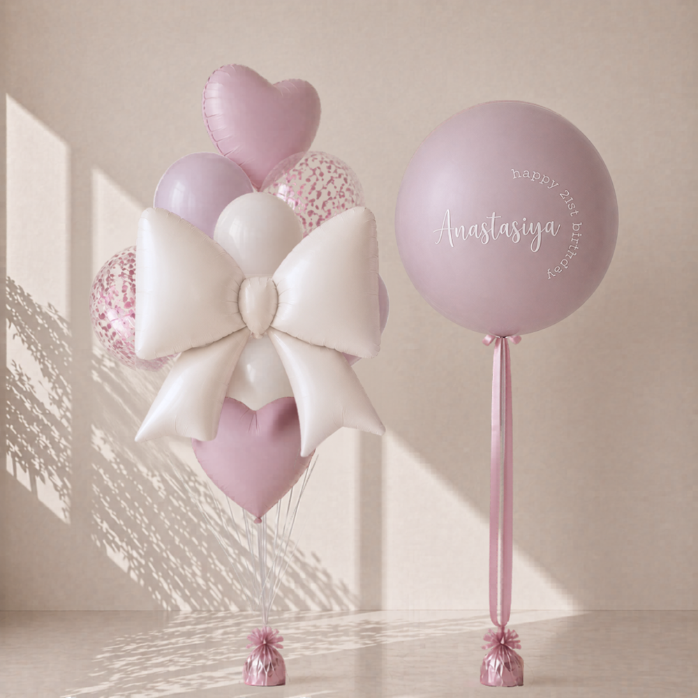 Decorative balloons with a large white bow and personalized balloon on a light background
