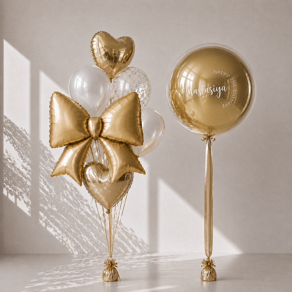 Gold balloons including a bow and heart shapes on a neutral background