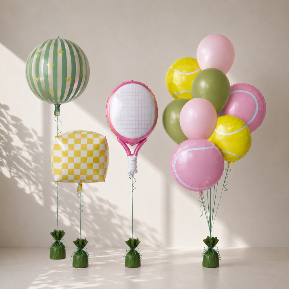 Colorful balloons shaped like tennis balls, racket, and hat on a neutral background