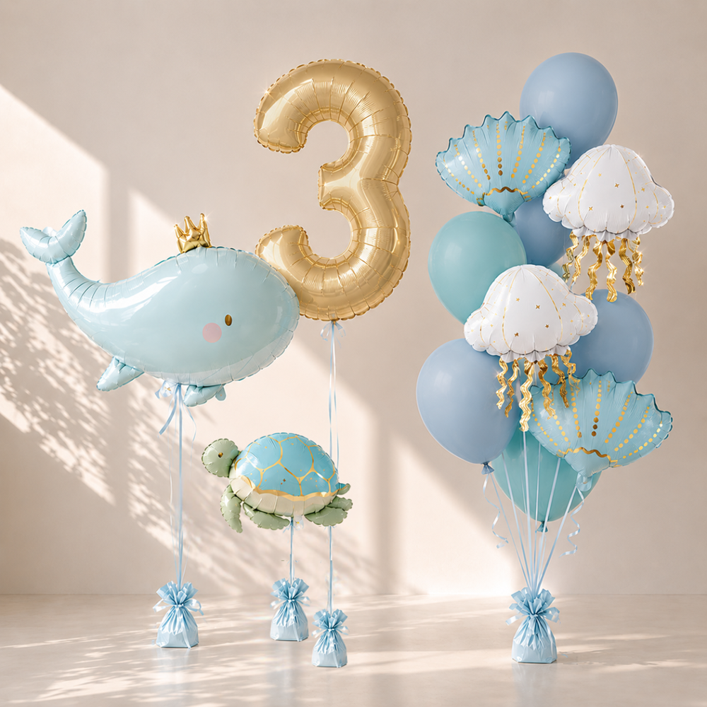 Collection of decorative balloons including a whale, number 3, turtle, and various sea-themed balloons on a neutral background.