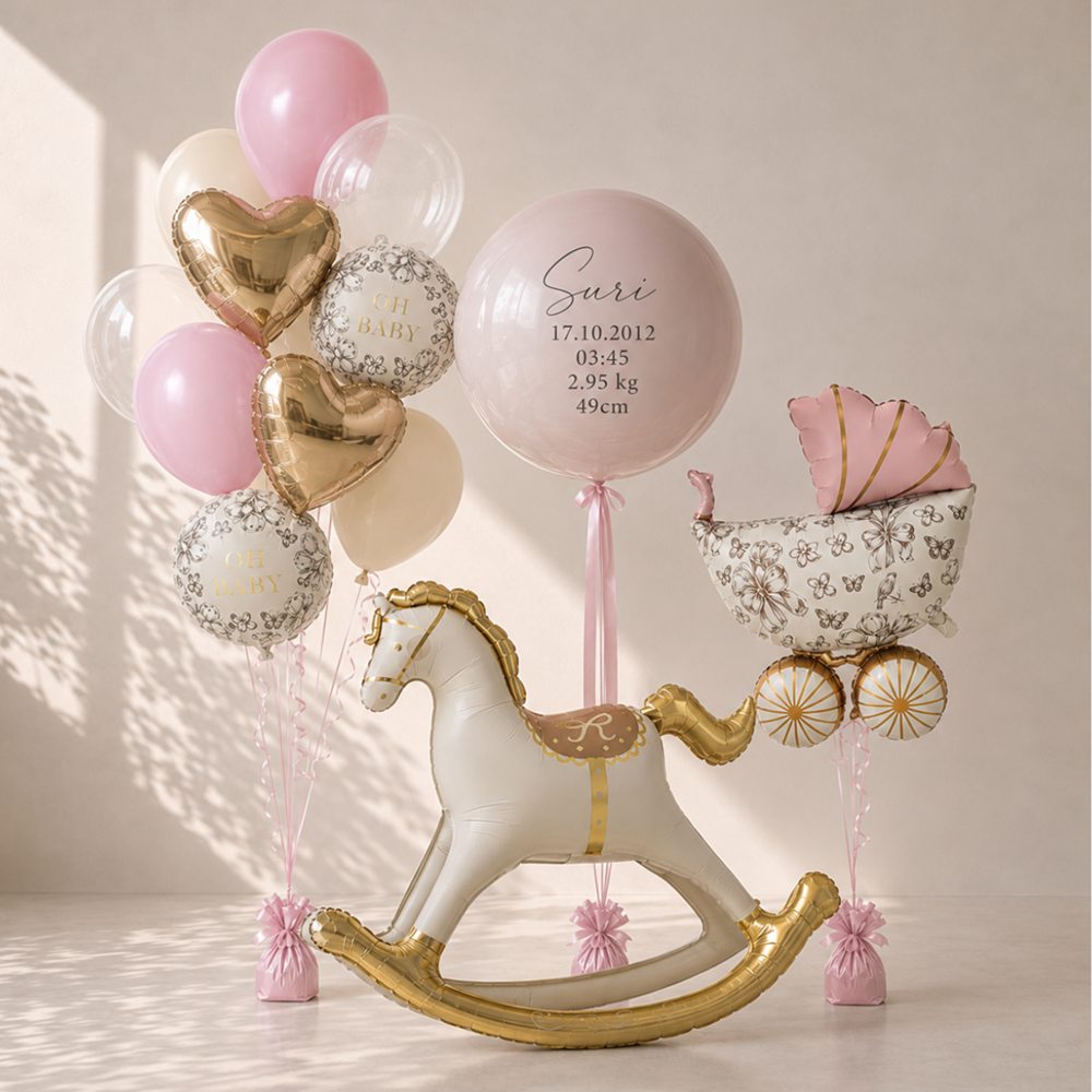 Decorative setup with balloons, rocking horse, and baby basket on a light background
