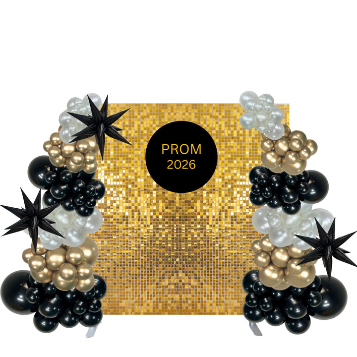 Prom backdrop banner with a gold sequin background, a central black circle reading 'PROM 2026', and balloon garlands in black, gold, and white with black star-shaped balloons on both sides.