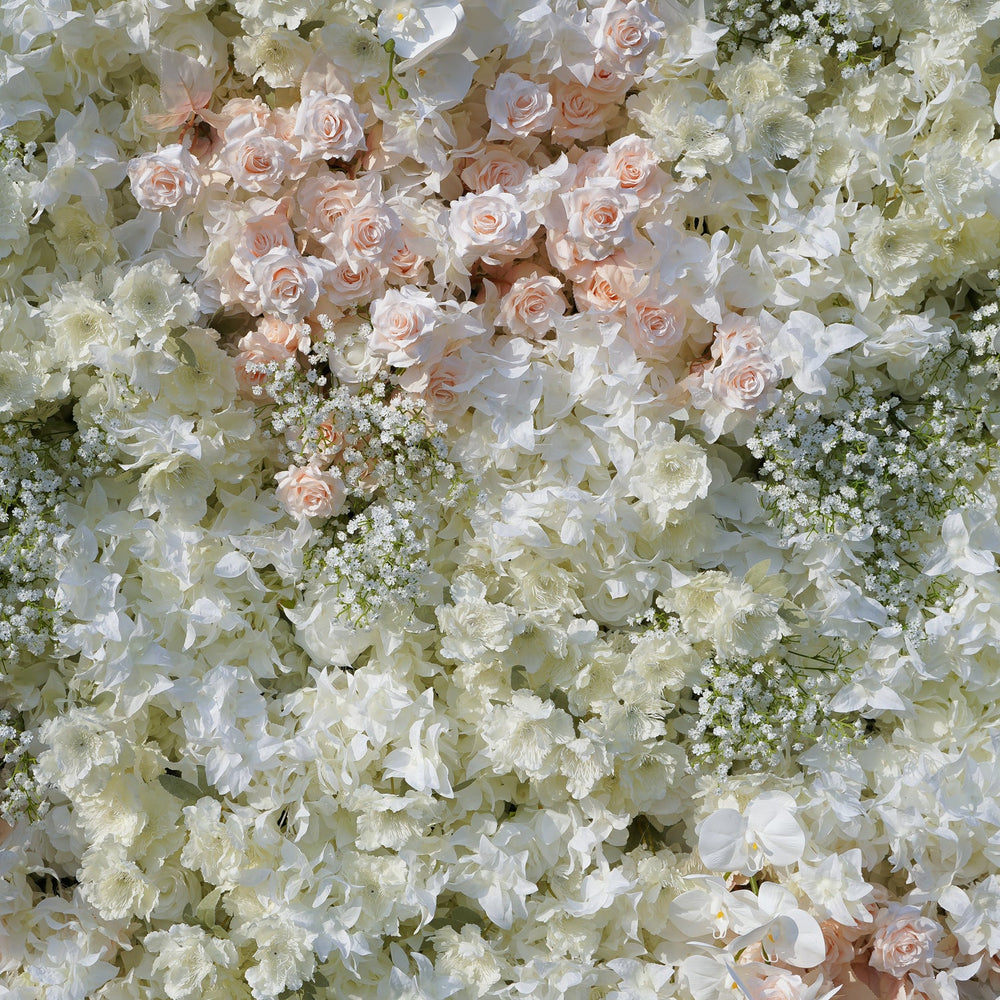 Wall of white and light pink flowers with greenery