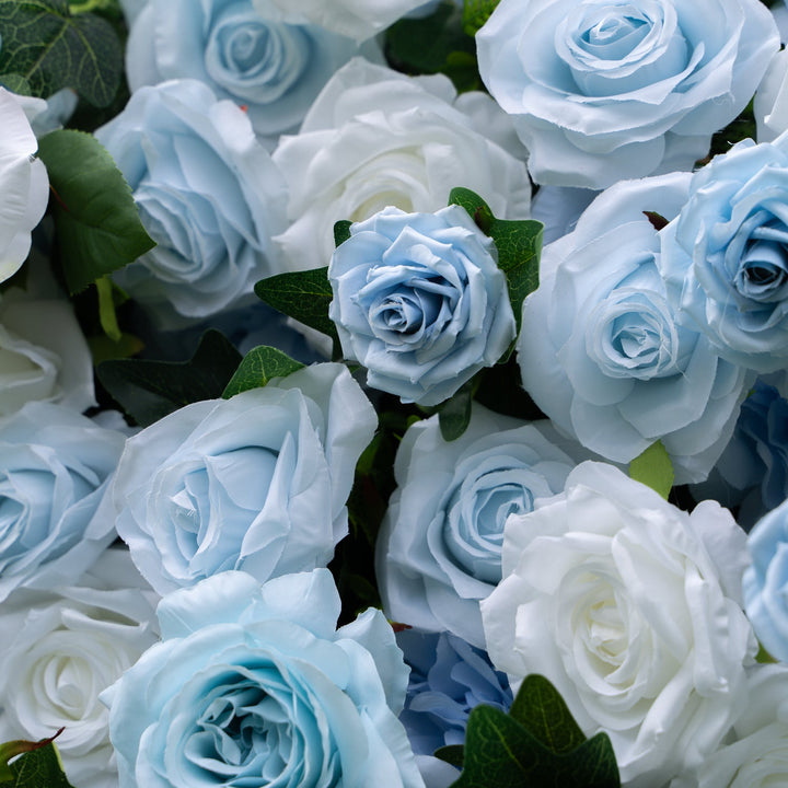 Close-up of blue and white roses with green leaves