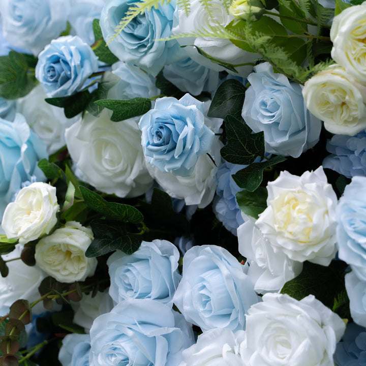 Close-up of blue and white roses with green leaves