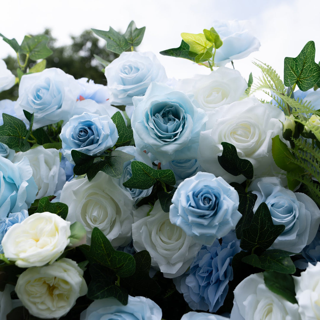 Bouquet of blue and white roses with green leaves.