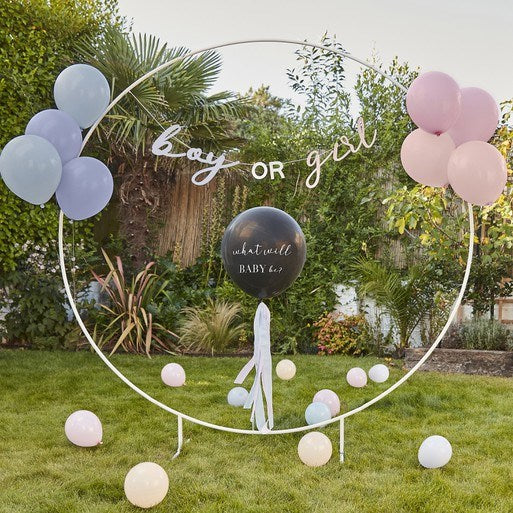 Gender reveal hoop backdrop with blue and pink balloons and black pop balloon.
