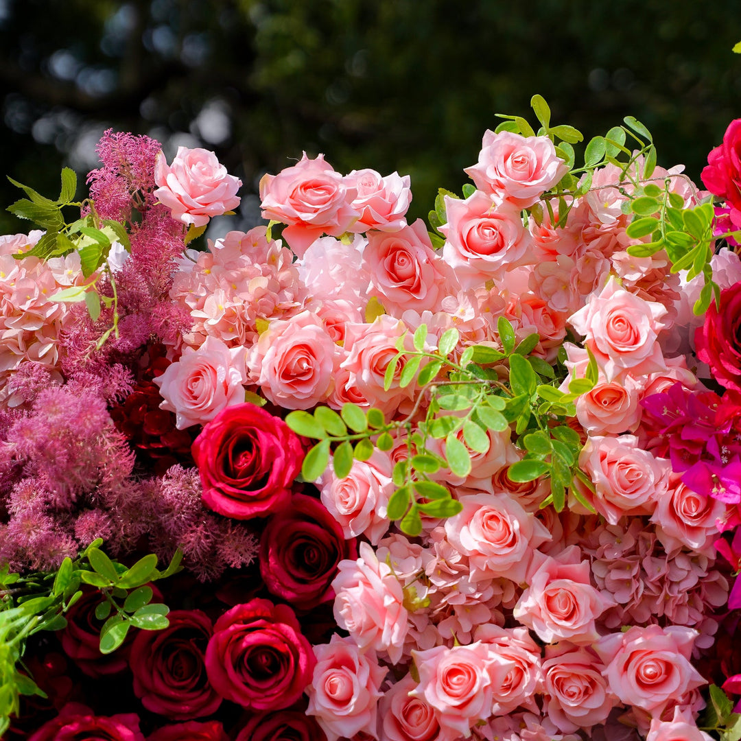 Bouquet of pink and red roses with green leaves against a blurred natural background