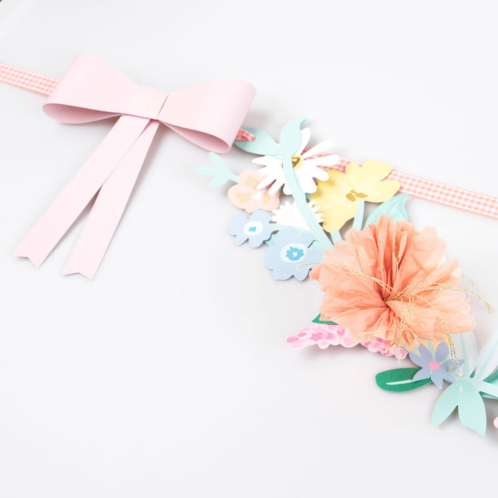Pastel-colored floral decorations with ribbons on a white background