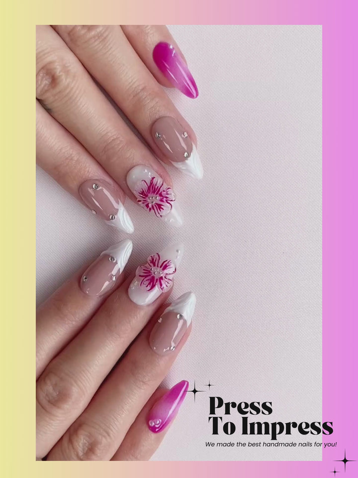 Video shows A hand holds a clear plastic case displaying press-on nails. The nails are glossy pink ombre, nude beige with white tips, and two white nails with pink floral designs.