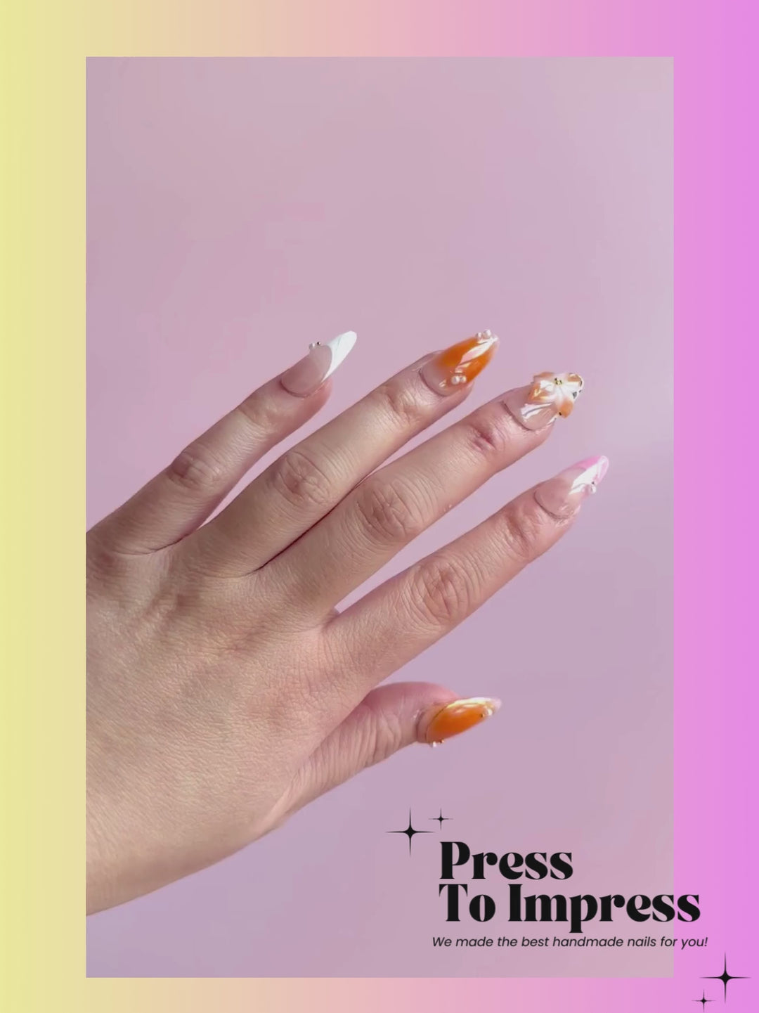 A Video shows A hand holds a clear plastic case displaying decorative press-on nails. The nails feature orange, beige, and light pink designs with floral and pearl accents.