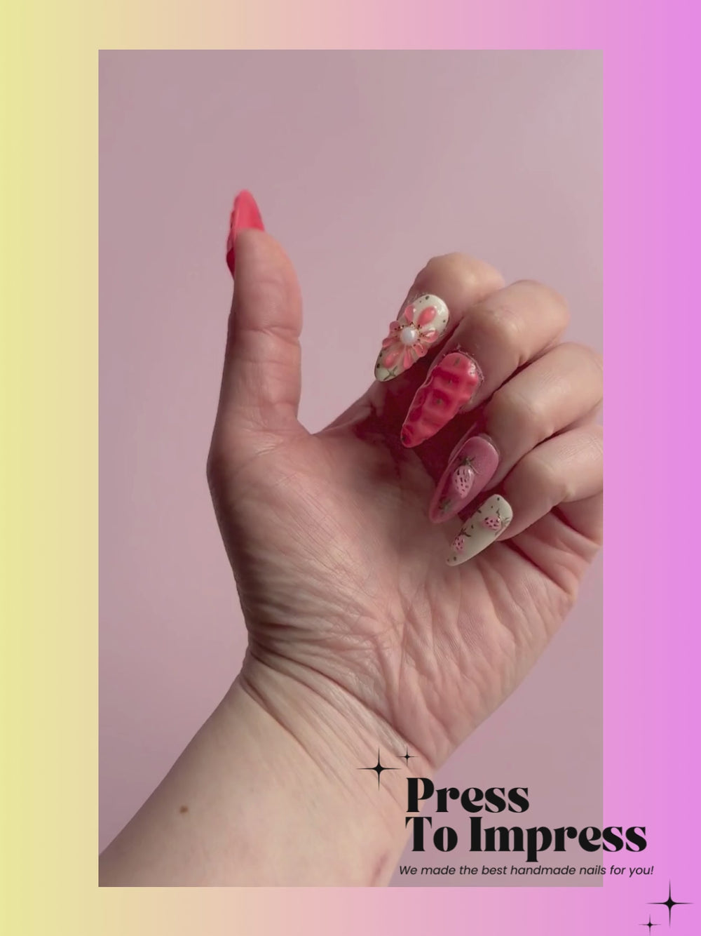 A Video shows A hand holds a clear plastic case containing 10 decorative press-on nails. The nails feature pink and white designs including strawberry patterns, flowers, and 3D embellishments.