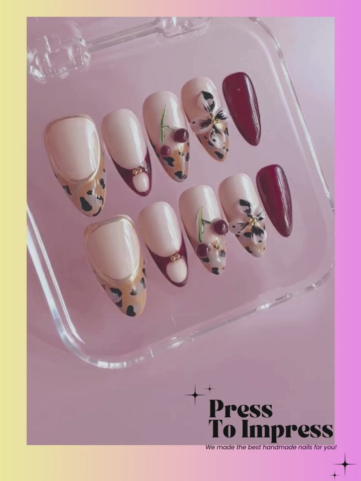 A videos shows A hand holds a clear plastic case displaying press-on nails with cream, brown, and leopard-print designs, set against a pink and yellow gradient background with 'Press To Impress' branding.