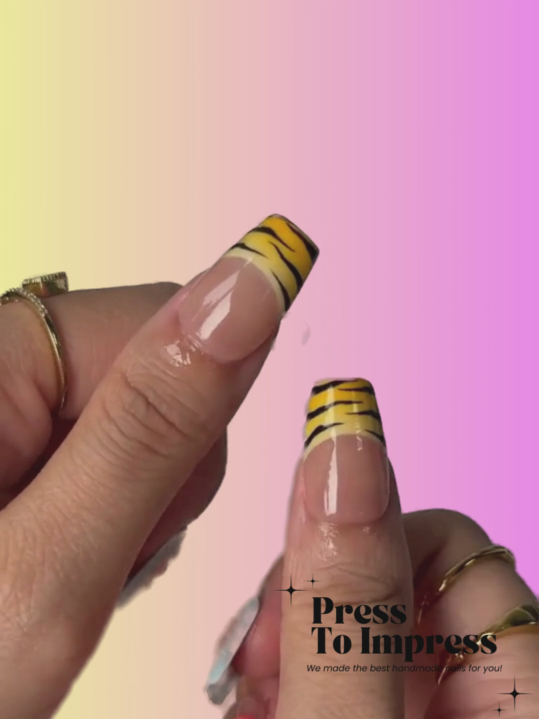 A Video shows A hand holds a clear plastic case displaying 10 press-on nails with a mix of beige, pink, light blue, yellow, black, and white designs, including stripes and floral patterns, against a pink and yellow gradient background with 'Press To Impress' branding.