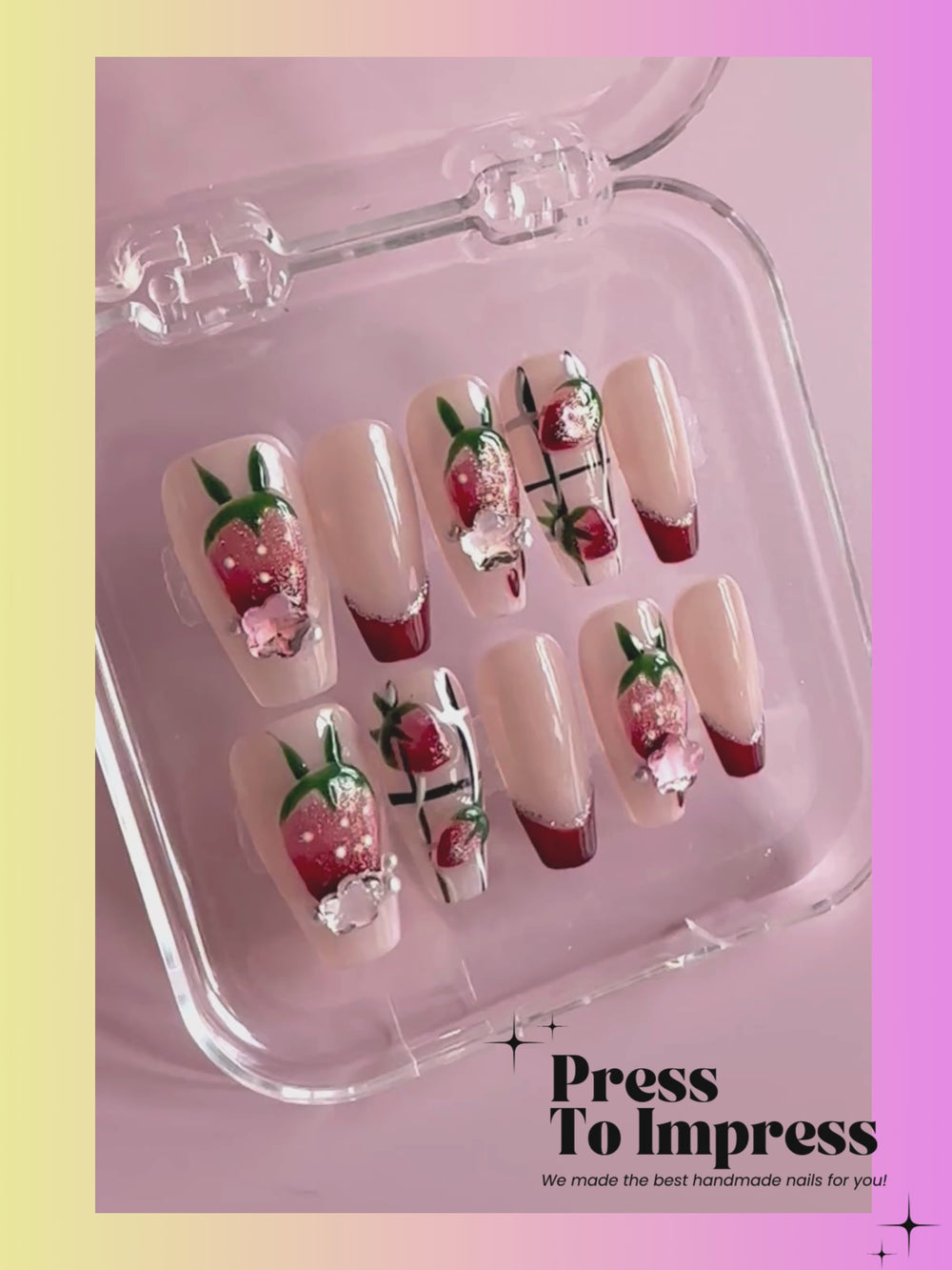 A video shows A hand holds a clear plastic case containing a set of decorative press-on nails. The nails have a French tip design with red and white gradients, some decorated with 3D strawberry details and small rhinestones.