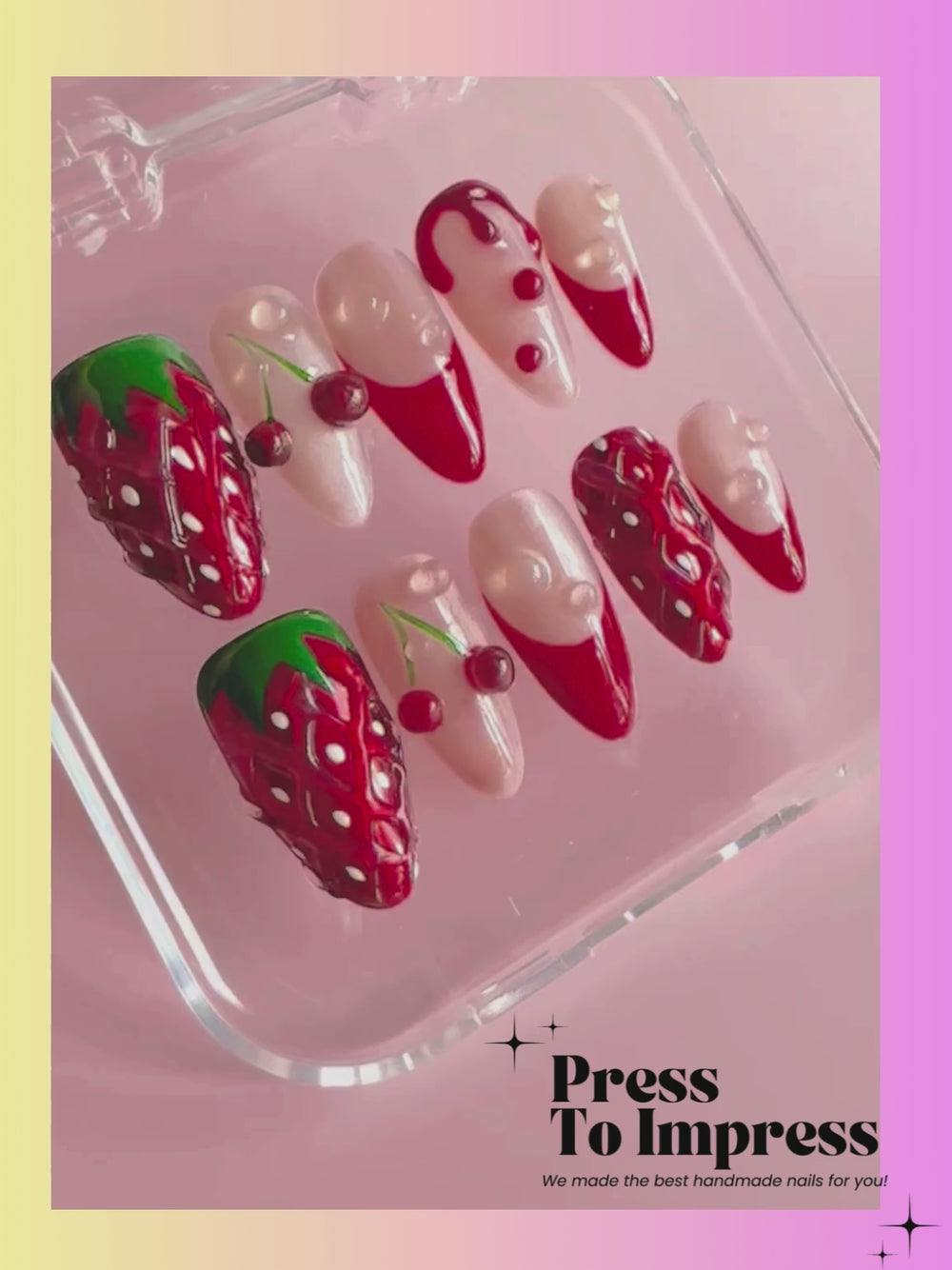 Video A hand holds a clear plastic case displaying 10 press-on nails with a strawberry and cherry theme, set against a pink and yellow gradient background with 'Press To Impress' branding.
