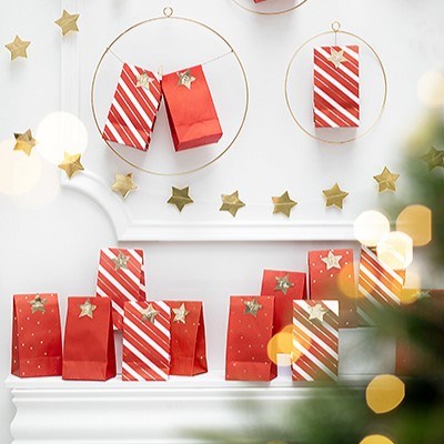 Christmas advent calendar display with red striped bags, gold stars, and hanging wire hoops.